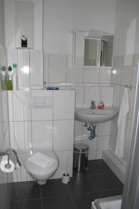 a white bathroom with a toilet and a sink at Johnny's wohnen auf Zeit in Duisburg
