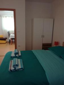 Un dormitorio con una cama verde con una manta verde en Sončne Terase, en Piran