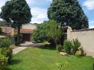 a yard with two trees and a house at Chambres d'Hôtes Mado et Lulu in Collonges-au-Mont-dʼOr