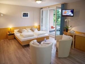 una camera da letto con un letto, due sedie e un tavolo di Hotel Garni Arnegg ad Arnegg