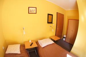 ポズナンにあるNest Nocleg Poznańのベッドルーム1室(ベッド2台、テーブル、ランプ付)