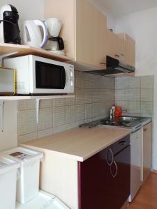 a kitchen with a microwave and a sink at Sončne Terase in Piran