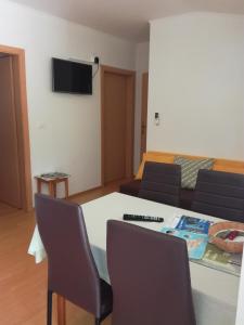 ein Wohnzimmer mit einem Tisch, Stühlen und einem Sofa in der Unterkunft Sončne Terase in Piran