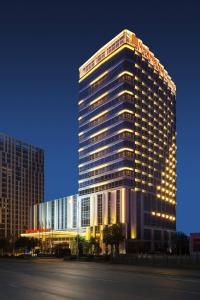 a tall building with lights on it at night at Wanda Realm Hotel Wuhu in Wuhu