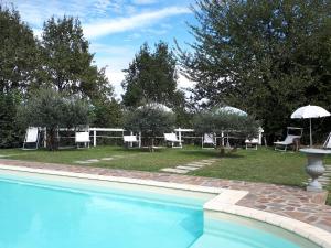 a swimming pool with chairs and a table and umbrella at Villagaia Country House in Montafia