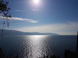 a large body of water with the sun in the sky at All Inclusive Hotel Piccolo Paradiso in Toscolano Maderno