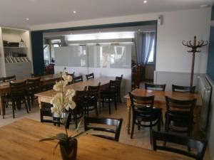 uma sala de jantar com mesas e cadeiras de madeira em Hotel Restaurant De La Roche em Les Sauvages