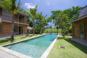 una piscina en un patio al lado de una casa en Alea Estate, en Kerobokan