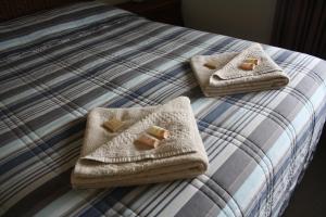 a bed with three towels on top of it at Isis Motel Scone in Scone