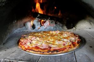 Eine Pizza kocht in einem Steinofen in der Unterkunft Isis Motel Scone in Scone