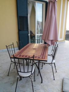 a table and chairs with a umbrella on a patio at Palazzo Della Monica in Vietri sul Mare