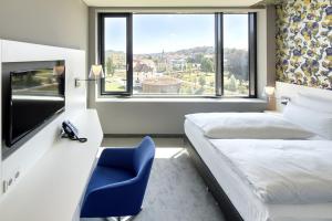 施瓦本格明德的住宿－雷姆斯帕克酒店，酒店客房,设有两张床和一张蓝色椅子