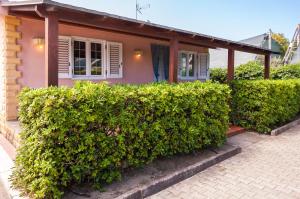 a house with green bushes in front of it at Villa Cicas sul mare in Campofelice di Roccella