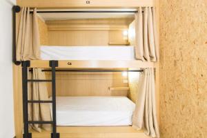 a bunk bed in a room with a ladder at Vestique hostel in Chiang Mai