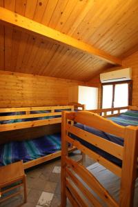 Campeggio Boscoverde في توري ديل لاغو بوتشيني: غرفة نوم مع سريرين بطابقين في كابينة