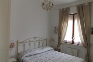 a bedroom with a bed and a window and a chandelier at Sea cottage in pinewood in Ginosa Marina