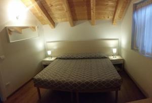 - une petite chambre avec un lit et 2 tables de chevet dans l'établissement B&B Tomaselli, à Strigno