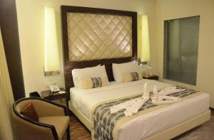 Habitación de hotel con cama y silla en Clarks Avadh, en Lucknow