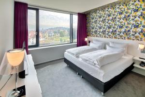 a bedroom with a bed and a large window at Hotel am Remspark in Schwäbisch Gmünd