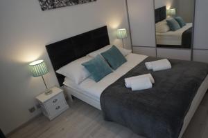 シュチェチンにあるDbD Apartament - Gray Turkusのベッドルーム1室(大型ベッド1台、枕2つ付)