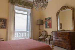 a bedroom with a bed and a dresser and a mirror at Casa Bellevue in Naples