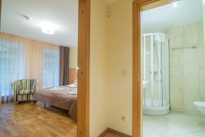 a bedroom with a bed and a bathroom with a shower at Guest House Milda in Druskininkai +33 photos