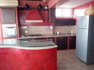 una cucina con frigorifero bianco e piano di lavoro rosso di Sky Wellness Apartment a Porto SantʼElpidio