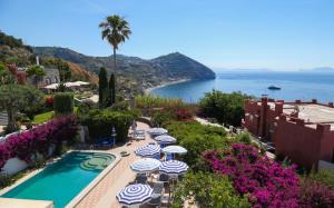 ein Resort mit einem Pool, Sonnenschirmen und dem Meer in der Unterkunft Hotel Loreley in Ischia