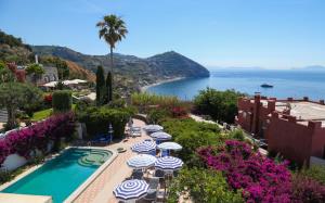 un complejo con piscina, sombrillas y océano en Hotel Loreley, en Isquia