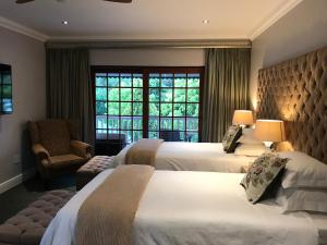 a hotel room with two beds and a window at Edenwood House in George