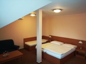 Habitación de hotel con 2 camas y escalera en Penzion Siesta, en Valtice
