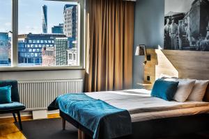 Una habitación de hotel con una cama y una ventana grande. en First Hotel Jörgen Kock, en Malmö