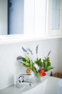 a vase of flowers sitting on top of a sink at Tenute Costadoria (Valle di Cynara) in Valledoria