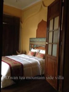 a bedroom with a bed and a wooden door at DWan Tea Mountain Side in Jatiluwih
