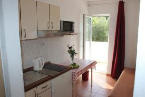 a kitchen with a table with a sink and a microwave at Dems in Živogošće