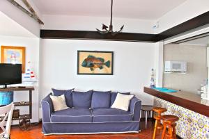 a living room with a blue couch in a room at Akisol Sesimbra Beach in Sesimbra