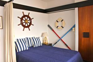 sypialnia z niebieskim łóżkiem i morską ścianą w obiekcie Akisol Sesimbra Beach w mieście Sesimbra