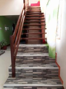 a staircase in a house with wooden railings and a staircase at David & Vhie Homestay-David's Guest House in El Nido