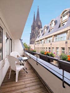 un balcón con mesa y sillas y un edificio en Callas am Dom, en Colonia