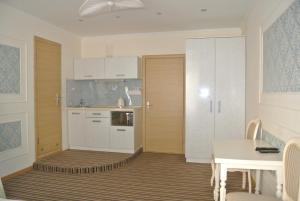 a kitchen with white cabinets and a table and a dining room at Mini Hotel on Poznyaky in Kyiv