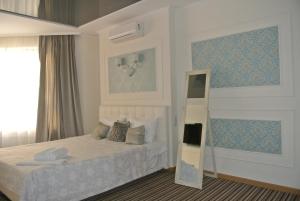 Schlafzimmer mit einem Bett und einem Spiegel in der Unterkunft Mini Hotel on Poznyaky in Kiew