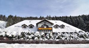 een met sneeuw bedekt gebouw met een bord erop bij Gościniec in Krynica Zdrój