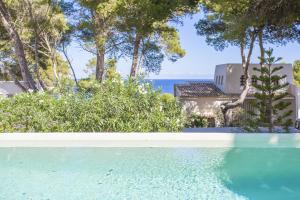 a swimming pool with a view of the ocean at Villa Cala Padri in Font de Sa Cala