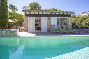 a villa with a swimming pool and a house at Villa Cala Padri in Font de Sa Cala