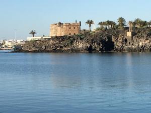 un castillo en una isla en un cuerpo de agua en Apartamento Las Palmeras Nazaret, en Nazaret