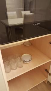 einem Schrank mit Schalen und Tellern sowie einer Mikrowelle in der Unterkunft Charming 2 Bedroom Apartment near the City's Biggest Mall in Baku + 27 Fotos