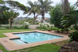 a swimming pool in a yard with trees at Mahogany House - SOLAR POWERED in Ballito