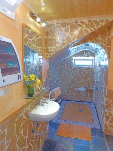 baño con lavabo y pared de piedra en La Alpispa, en Valleseco