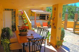 a patio with a table and chairs and a house at La Alpispa in Valleseco