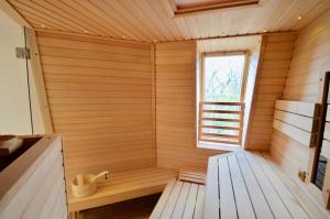una sauna de madera con ventana en una habitación en Villa Strandblick 10, en Zingst